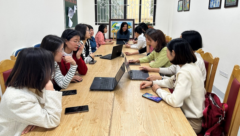 A group of people sitting at a table with laptops

Description automatically generated